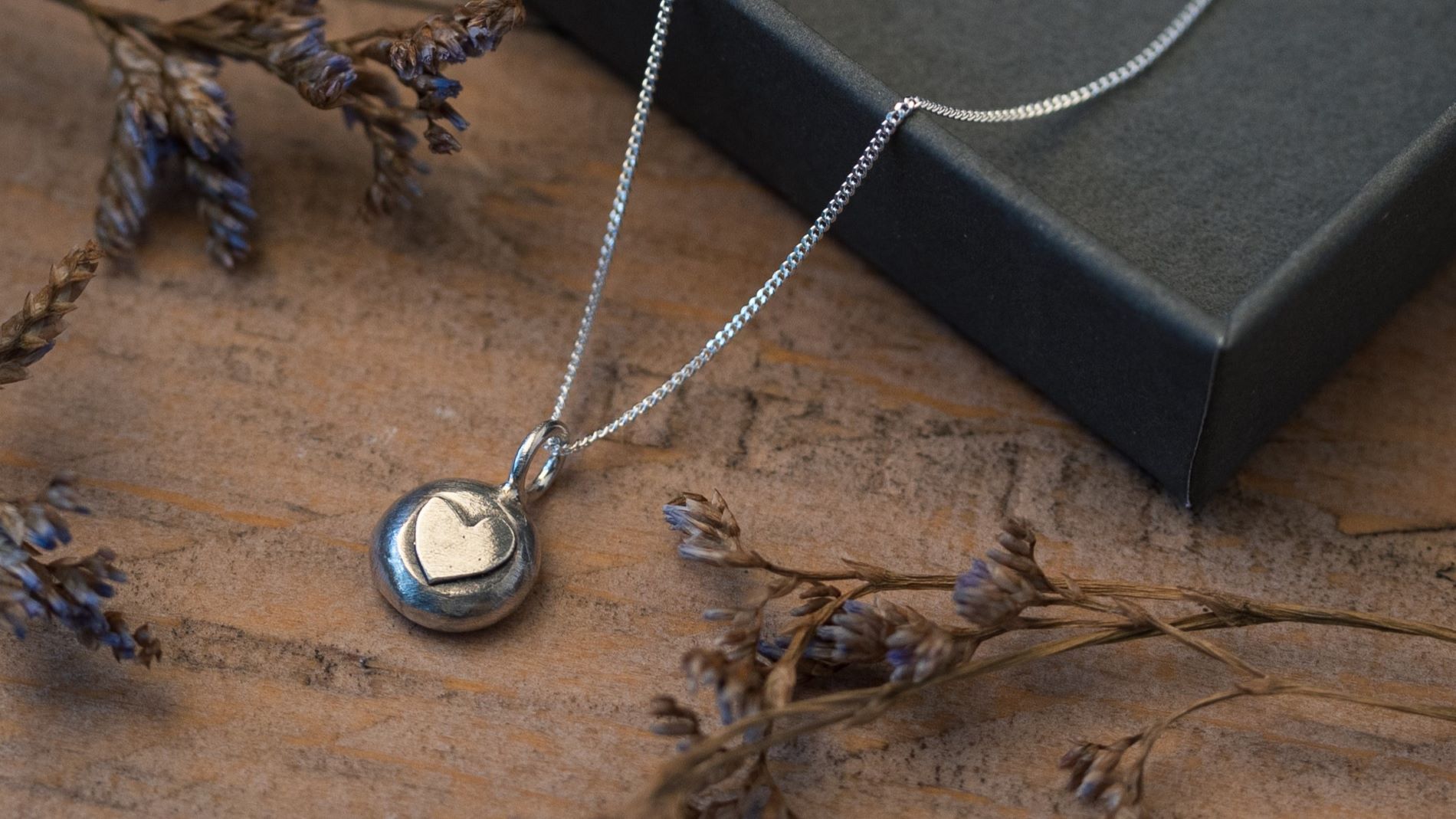 Handmade silver pebble pendant with copper heart
