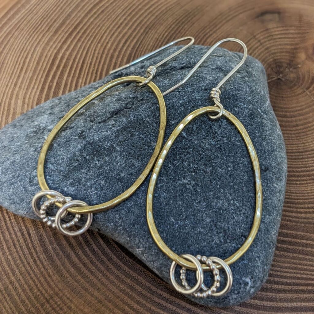 Textured oval brass dangly earrings with silver accent rings