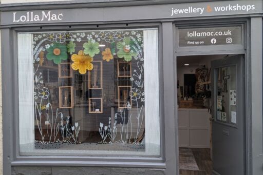 shop window decorated with spring inspired display of green and yellow flowers